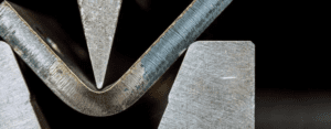 Operação de corte de chapa de aço com guilhotina industrial de alta precisão na Mikro Stamp, empresa de estamparia e conformação metálica em Campinas.